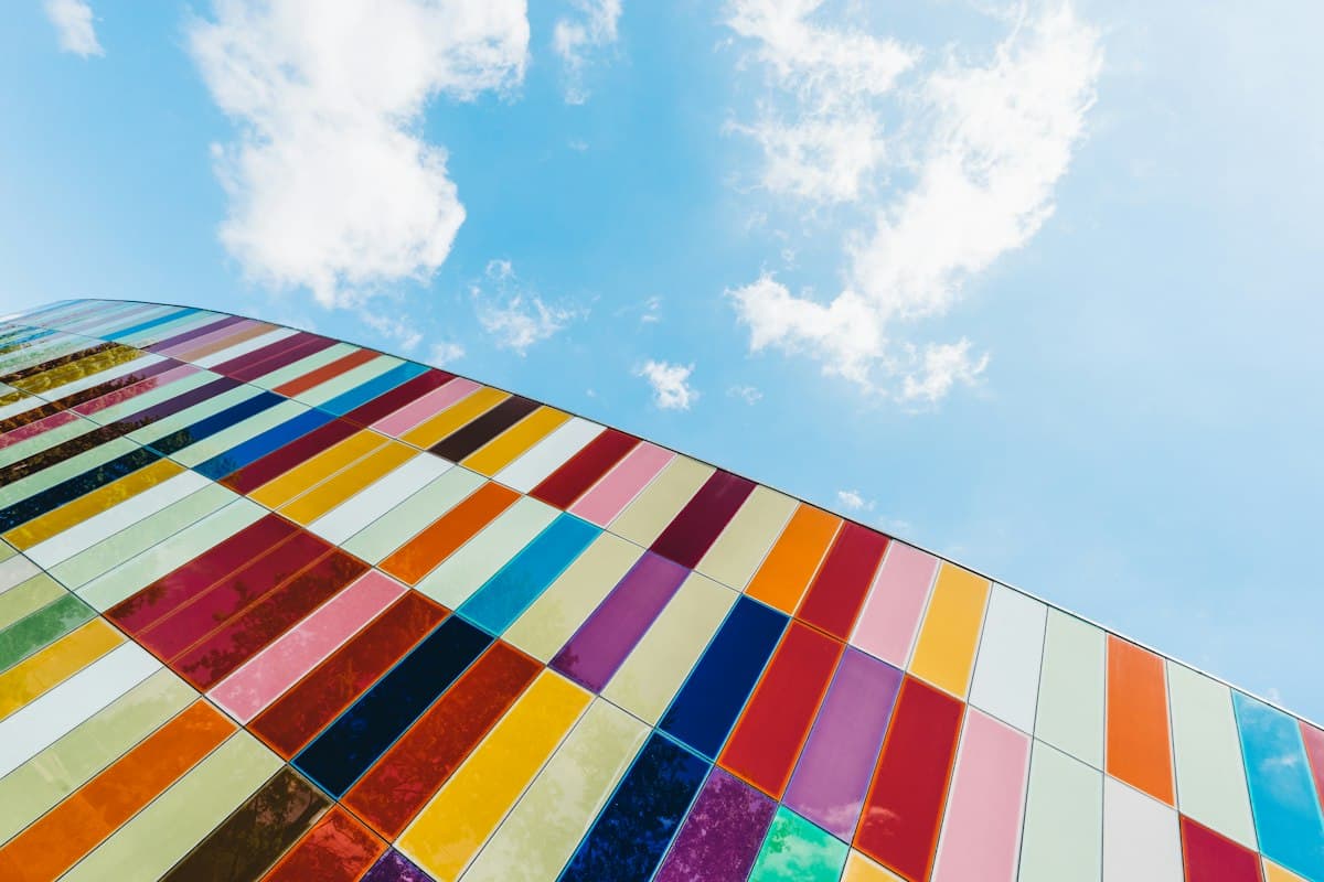 Multicolored glass facade of a building against a cloudy sky